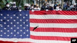 在911事件19周年纪念仪式中，当美国国歌响起时一面美国国旗在国家911纪念馆前展开。（2020年9月11日）