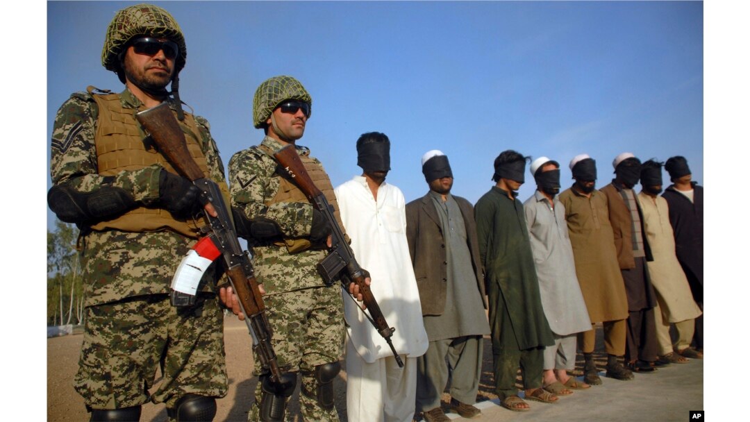 FILE - Pakistani paramilitary soldiers guard suspects arrested during a search operation in Shah Kass, an area of Pakistan's Khyber tribal region along the Afghan border, March 3, 2017.