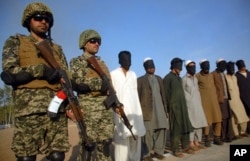 FILE - Pakistani paramilitary soldiers guard suspects arrested during a search operation in Shah Kass, an area of Pakistan's Khyber tribal region along the Afghan border, March 3, 2017.