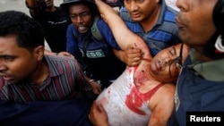 방글라데시 다카에서 시위대와 경찰이 충돌해 수백명의 사상자가 발생한 가운데, 기자들이 부상당한 경찰을 옮기고 있다.
