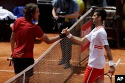 Srpski tenizer Novak Đoković čestita Grku Stefanosu Cicipasu nakon pobede u meču Otvorenog turnira u Rimu, u Rimu, Italija, 15. maja 2021. (AP Photo/Gregorio Borgia)