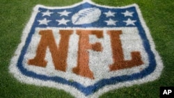 FILE - An NFL logo is displayed on the field before an NFL football game between the New England Patriots and the Denver Broncos in Denver, Nov. 12, 2017. Fox and the NFL have agreed to a five-year deal for Thursday night football games, Fox announced Wednesday.