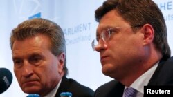 FILE - EU Energy Commissioner Guenther Oettinger (L) and Russian Energy Minister Alexander Novak are seen at a news conference in Berlin May 19, 2014.