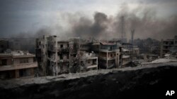 FILE - Smoke rises over Saif Al Dawla district, in Aleppo, Syria, Oct. 2, 2012. 