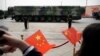 Los espectadores ondean banderas chinas mientras vehículos militares con misiles balísticos DF-41 ruedan durante un desfile en Beijing, China, el 1 de octubre de 2019.