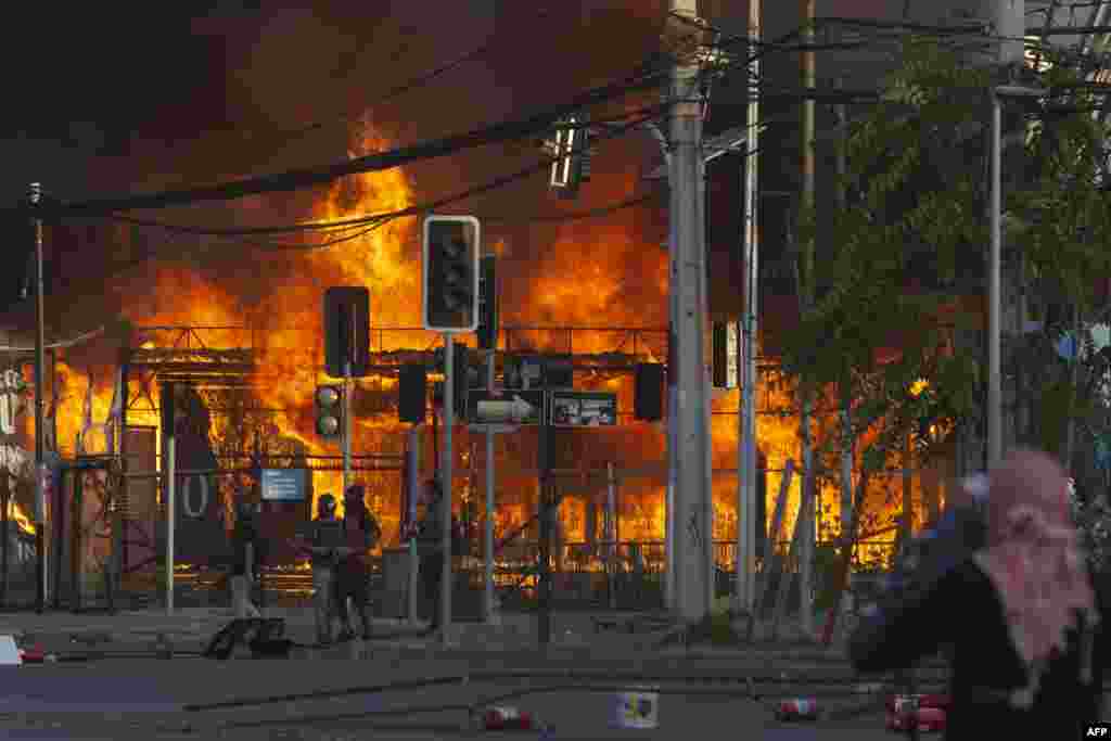 Protesters set a construction site on fire during a ceremony outside the Monumental stadium in Santiago, Chile, Jan. 29, 2020, for the death of Colo Colo supporter Jorge Mora, who was run over by a police truck.