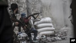 A rebel fighter retreats from government fire during clashes at the Moaskar front line, Aleppo, Syria, Oct. 24, 2012.