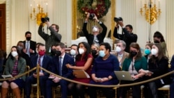 Members of the White House press corps listen as President Joe Biden speaks about the COVID-19 response and vaccinations, in the State Dining Room of the White House in Washington, Dec. 21, 2021.