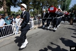 Turkish police officers carry the coffins of police officers Feyyaz Yumusak and Okan Acar, during a funeral procession in Sanliurfa, southeastern Turkey, July 23, 2015.