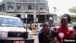 FILE - A woman reacts near the scene of a blast in Kampala, Uganda, Nov. 16, 2021. 