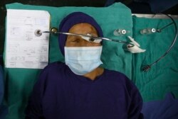 Seorang pasien terbaring di ranjang rumah sakit setelah menerima anestesi menjelang operasi katarak di Tilganga Eye Center, Kathmandu, Nepal, 26 Maret 2021.