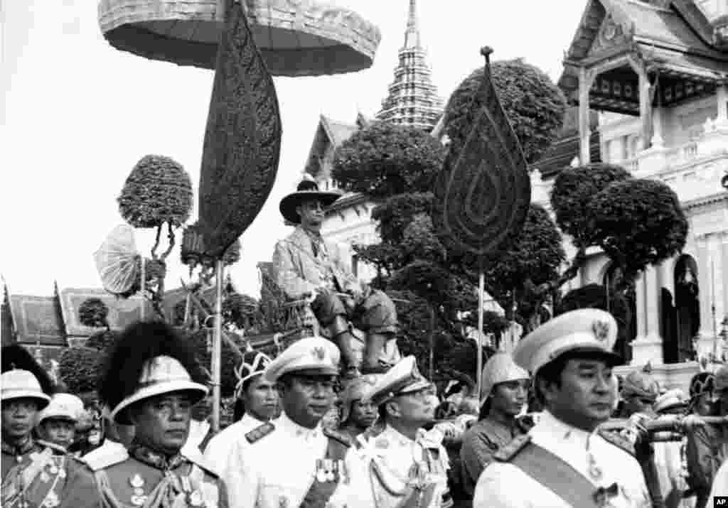 King Bhumibol Adulyadej is carried on the shoulders of Royal guards during a parade in Bangkok Dec. 7, 1963. The parade climaxed one week-long celebration of the King&#39;s 36th birthday.