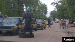 Member of vigilante groups popularly called "civilian JTF" monitors traffic on used tire, Mafoni village, Borno state, Aug. 6, 2013.