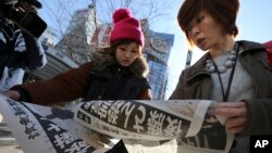 日本民眾2月1日閱讀報紙上﹐有關日本記者后藤健二被伊斯蘭國激進組織殺死的報導。