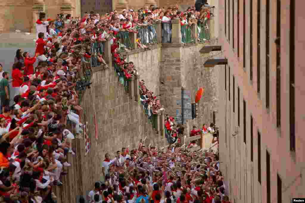 Runners participate in the traditional singing before the running of the bulls, during the San Fermin festival in Pamplona, Spain.