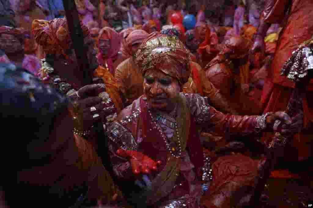 Hindu men from the village of Nandgaon, smeared with colors, play holi at the Ladali or Radha temple before taking out a procession for the Lathmar Holi festival, at the legendary hometown of Radha, consort of Hindu God Krishna, in Barsana, 115 kilometers (71 miles) from New Delhi, India.