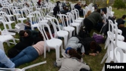 Israelis react, Dec. 29, 2017, as sirens indicate rockets going off during an event for Israeli soldier Oron Shaul whom Israel believes died in the Gaza Strip and Hamas said it had captured during the Israeli Gaza war on 2014.