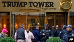 FILE - A heavily armed New York City police officer stands guard outside the Fifth Avenue public entrance to Trump Tower in New York, Nov. 15, 2016.