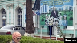 Cử tri đi ngang một áp phích tranh cử của Tổng thống Uzbekistan và ứng cử viên tổng thống Islam Karimov gần một trạm bỏ phiếu ở Tashkent, ngày 29/3/2015.