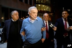 Jose Maria Marin, center, leaves federal court in the Brooklyn borough of New York, Nov. 3, 2015. The Brazilian FIFA official, who was a key organizer of the 2014 World Cup in his home country pleaded not guilty to U.S. charges stemming from a sprawling bribery case that has scandalized the soccer world.