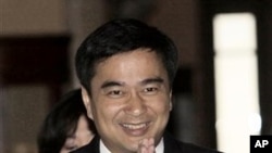 Thai Prime Minister Abhisit Vejjajiva greets as he walks on the hallway of the Government House in Bangkok, May 9, 2011