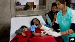 An injured passenger and her son share a bed as they are treated at a hospital in Kanpur, in the northern Indian state of Uttar Pradesh, India, Nov. 21, 2016.