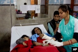 An injured passenger and her son share a bed as they are treated at a hospital in Kanpur, in the northern Indian state of Uttar Pradesh, India, Nov. 21, 2016.