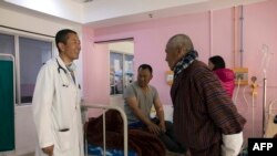 Perdana Menteri Bhutan Lotay Tshering (kiri) berbicara dengan para pasien saat dia memeriksa para pasien di Rumah Sakit Rujukan Nasional di ibu kota Bhutan, Thimpu, 30 Maret 2019. (Foto: AFP)
