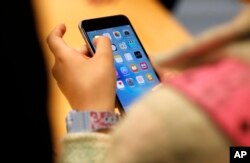 In this Sept. 25, 2015, file photo, person tries out the new Apple iPhone 6S at an Apple store on Chicago's Magnificent Mile in Chicago.