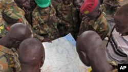 Soldiers from the Sudan People's Liberation Army (SPLA) examine a map at the frontline position in Pana Kuach, Unity State, South Sudan, Friday May 11 2012. In late April, tensions between Sudan and South Sudan erupted into conflict along their poorly def