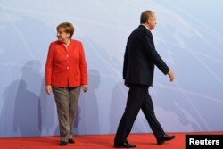 FILE - German Chancellor Angela Merkel and Turkey President Recep Tayyip Erdogan go their separate ways after a handshake greeting at the beginning of the G20 summit in Hamburg, Germany, July 7, 2017.
