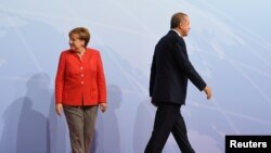 German Chancellor Angela Merkel and Turkey President Recep Tayyip Erdogan go their separate ways after a handshake greeting at the beginning of the G20 summit in Hamburg, Germany, July 7, 2017.