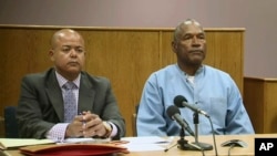 Former NFL football star O.J. Simpson appears with his attorney, Malcolm LaVergne, left, via video for his parole hearing at the Lovelock Correctional Center in Lovelock, Nev., on Thursday, July 20, 2017. Simpson was convicted in 2008 of enlisting some men he barely knew, including two who had guns, to retrieve from two sports collectibles sellers some items that Simpson said were stolen from him a decade earlier. (Lovelock Correctional Center via AP)