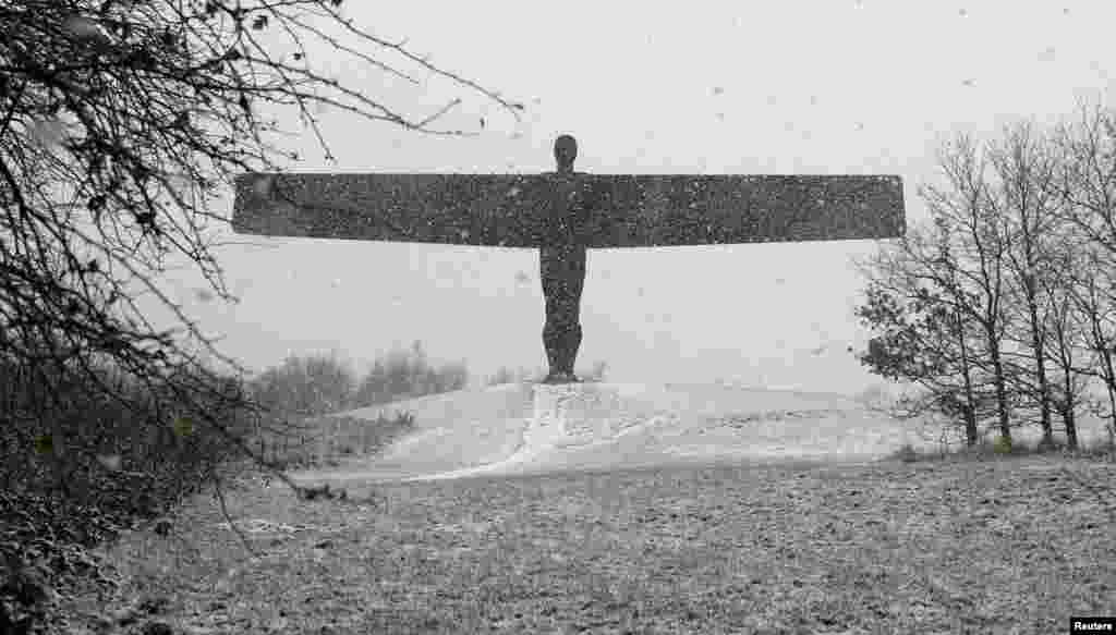 Snow falls around the Angel of North near Gateshead, Britain.