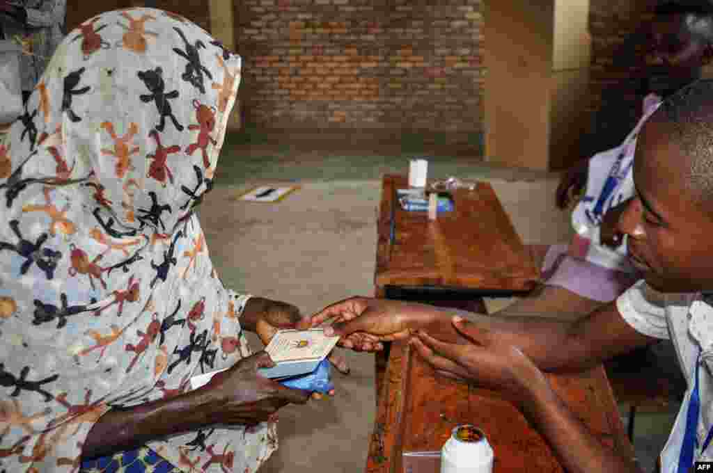 Une femme reçoit sa carte d'identité après avoir voté dans un bureau de vote à Bujumbura, le 17 mai 2018.