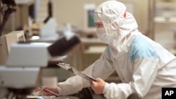 芯片技术人员在台湾联华电子公司（UMC）的“洁净室”测试设施检查硅片（资料照）
