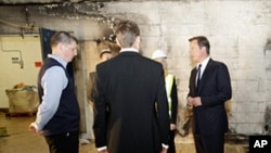 Britain's Prime Minister David Cameron (r) visits a looted Liddell supermarket in Salford, England, Aug. 12, 2011
