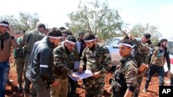 Turkey-backed Free Syrian Army fighters advance in Der Mismis village in the southeast portion of Afrin, Syria, March 13, 2018. Turkish troops and allied Syrian opposition fighters have intensified attacks on the Syrian Kurdish-held town of Afrin.