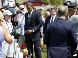 FILE - Then-President Barack Obama talks to family members of fallen soldiers near the graves in Section 60 of Arlington National Cemetery, in Arlington, Virginia, May 30, 2011.