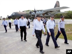 Jan. 28, 2016 file photo released by the Taiwan Presidential Office, Taiwan's President Ma Ying-jeou, second from right, arrives on his visit to the Taiping Island, also known as Itu Aba, in the Spratly archipelago, in the South China Sea.