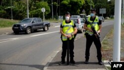 Des gendarmes sur la route de Saint Michel, le jour du vote pour le référendum sur l'indépendance, au Mont Dore, sur le territoire français de Nouvelle-Calédonie, le 12 décembre 2021.