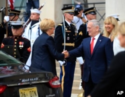 FILE - Defense Secretary Jim Mattis greets Italy's Defense Minister Roberta Pinotti, during an honor cordon at the Pentagon, July 11, 2017.