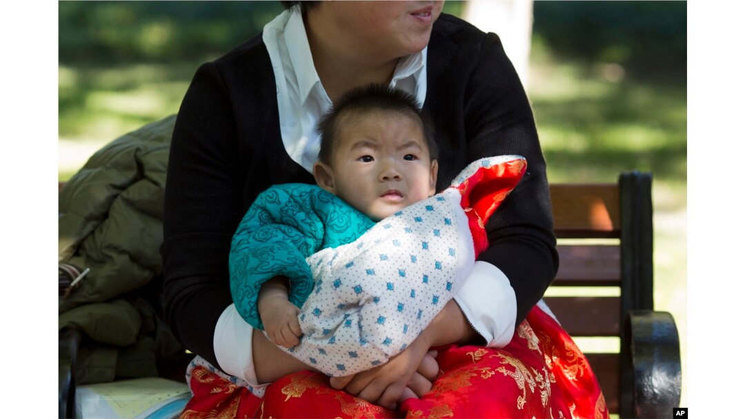 FILE - A child is wrapped up against the cold at a park in Beijing, China.