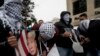 Palestinians holds posters of the U.S. President Donald Trump during a protest in the West Bank City of Ramallah, Dec. 6, 2017. 