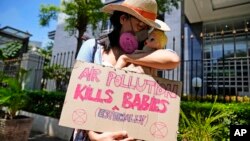 Un activista muestra un cartel con una muñeca que representa a los bebés afectados por la contaminación del aire durante una protesta frente al Tribunal de Distrito de Yakarta Central, Indonesia, en septiembre de 2021.