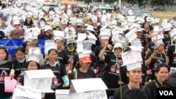 Protesters wore black T-shirts and paper houses as hats and called on the government to provide them with better housing and resettlement. 