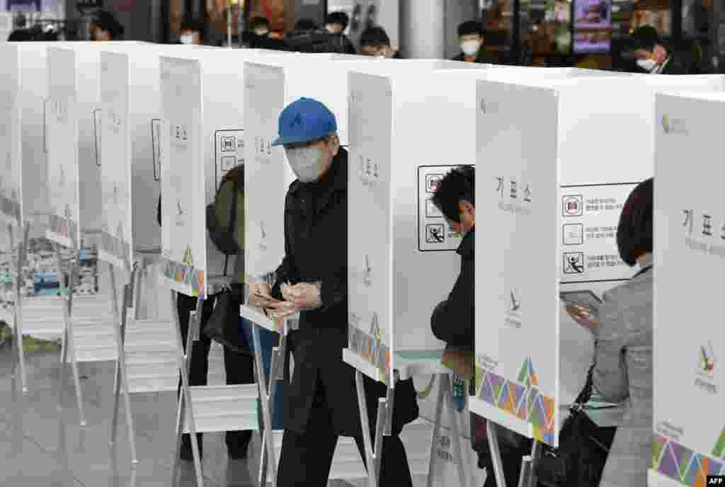 A South Korean man casts a ballot during early voting ahead of next week&#39;s parliamentary elections, at a polling station in Seoul. 