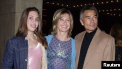 Olivia Newton-John (centro) con su hija Chloe y Patrick McDermott. Foto de archivo 2001. McDermott desapareció en 2005 durante un viaje de pesca. En 2008 fue declarado oficialmente muerto. Ahora ha sido descubierto viviendo en Nayarit, México.