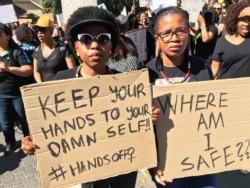Two young protesters hold signs in Sandton, Johannesburg, Sept. 13, 2019. (T.Khumalo/VOA)
