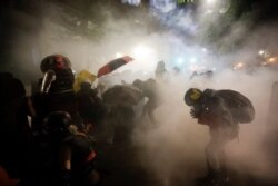 Federal officers launch tear gas at a group of demonstrators during a Black Lives Matter protest at the Mark O. Hatfield United States Courthouse in Portland, Oregon, July 26, 2020.